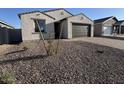 A single-story home with a two-car garage and low maintenance gravel yard at 15773 W Beryl Ave, Waddell, AZ 85355