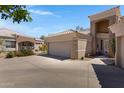 A desert home featuring a driveway, three car garage and desert landscaping at 16450 E Ave Of The Fountains -- # 14, Fountain Hills, AZ 85268