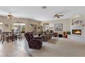 Spacious living room featuring neutral tones, a fireplace, ceiling fans, an eat-in kitchen and multiple sitting areas at 16450 E Ave Of The Fountains -- # 14, Fountain Hills, AZ 85268