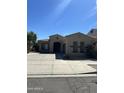 Charming single-story home with arched entry, manicured landscaping, and concrete driveway at 17447 W Yavapai St, Goodyear, AZ 85338