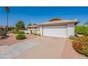 Attractive one-story home with well-manicured desert landscaping, a long driveway, and a two-car garage at 1871 Leisure World --, Mesa, AZ 85206