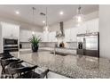 Bright and airy kitchen featuring white cabinets, granite countertops, stainless steel appliances, and pendant lighting at 19038 N Arbor Dr, Maricopa, AZ 85138