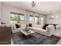 Stylish living room featuring a large sectional sofa, modern decor, and ample natural light at 19038 N Arbor Dr, Maricopa, AZ 85138