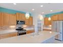 Well-lit kitchen features quartz countertops, stainless appliances, and decorative pendant lights at 26733 W Melinda Ln, Buckeye, AZ 85396