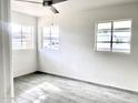 Corner bedroom featuring wood-look tiled floors and bright natural light from multiple windows at 2925 N 19Th Ave # 97, Phoenix, AZ 85015