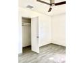 Bedroom with wood-look tiled floors, ceiling fan, and closet with open door at 2925 N 19Th Ave # 97, Phoenix, AZ 85015