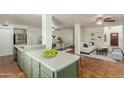 Open-concept kitchen flows into dining and living areas, featuring tiled floor, green cabinets, and stainless appliances at 3030 W Christy Dr, Phoenix, AZ 85029