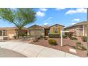 Lovely home featuring desert landscaping, a mature tree, a paver driveway and a two car garage at 31318 N 26Th Dr, Phoenix, AZ 85085