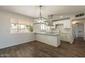 Bright kitchen and dining area with hardwood floors, featuring a stylish light fixture and a breakfast bar at 3441 W Sweetwater Ave, Phoenix, AZ 85029