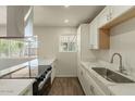 A modern kitchen featuring sleek countertops, a stainless steel range hood, and ample natural light at 3441 W Sweetwater Ave, Phoenix, AZ 85029