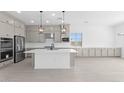 Bright, open kitchen with stainless steel appliances, white countertops, and modern pendant lighting at 37785 W Santa Maria St, Maricopa, AZ 85138