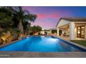 Gorgeous pool with water feature surrounded by mature landscaping at 3912 E Ellis St, Mesa, AZ 85205