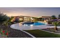 A backyard oasis featuring a luxurious pool with rock features, a spa, and a covered patio area perfect for relaxation at 4547 S Banning Dr, Gilbert, AZ 85297