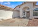 Inviting arched entrance with decorative wreath and desert landscaping around the single-story home at 515 W Smoke Tree Rd, Gilbert, AZ 85233