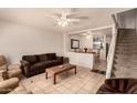 Inviting living room with tile flooring, ceiling fan, and stairs leading to the upper level at 5808 E Brown Rd # 119, Mesa, AZ 85205