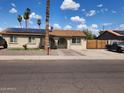 Charming single-story home with a well-maintained yard, solar panels, and mature palm trees at 5916 W Coronado Rd, Phoenix, AZ 85035