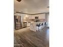 Bright kitchen features white cabinets, stainless appliances, and center island with bar seating at 5916 W Coronado Rd, Phoenix, AZ 85035