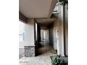 Covered walkway outside of apartments, showing tile floors, rock pillars, and apartment doors at 7609 E Indian Bend Rd # 1012, Scottsdale, AZ 85250