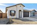 View of front of home with desert landscaping, black shutter, and dark two car garage at 7657 W Minton St, Laveen, AZ 85339