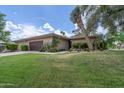 Charming home with a well-manicured lawn, desert landscaping, and a stylish wood garage door at 7746 E Bisbee Rd, Scottsdale, AZ 85258