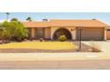 Inviting single-story home with manicured lawn, complemented by mature trees and a two-car garage at 10603 W Ruth Ave, Peoria, AZ 85345