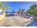 Cozy single-story home featuring a large driveway and xeriscaped yard with a mature tree at 10917 W Apache St, Avondale, AZ 85323