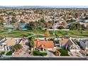 Aerial view of a home with a red tile roof, a manicured lawn, and a neighborhood park nearby at 1101 N Peppertree Dr, Gilbert, AZ 85234