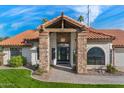 Inviting home featuring stone columns, a covered entryway, a decorative front door, and manicured landscaping at 1101 N Peppertree Dr, Gilbert, AZ 85234