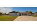 Home exterior featuring a long driveway leading to the garage and well-kept lawn at 15202 N 71St Dr, Peoria, AZ 85381
