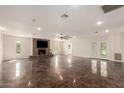 Spacious living room features tile floors, a cozy brick fireplace, and recessed lighting at 15202 N 71St Dr, Peoria, AZ 85381