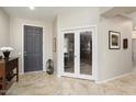 Bright foyer with tiled floors, leading to a study and other living spaces at 15434 W Big Sky Dr, Surprise, AZ 85374