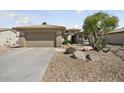 View of the home's facade, featuring a two-car garage and desert landscaping at 15434 W Big Sky Dr, Surprise, AZ 85374
