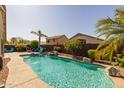 Backyard boasts a gorgeous pool surrounded by lush greenery and ample space for relaxation at 16577 W Garfield St, Goodyear, AZ 85338