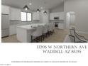 Modern kitchen with a large island, stainless steel appliances, pendant lighting, and white cabinetry at 17205 W Northern Ave, Waddell, AZ 85355