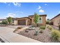 Inviting single-story home featuring a two-car garage, desert landscaping, and a stone pathway at 175 E Santa Lucia Ln, Queen Creek, AZ 85140