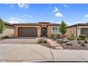Charming single-story home with a two-car garage, desert landscaping, and a paver walkway at 175 E Santa Lucia Ln, Queen Creek, AZ 85140
