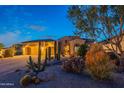 A charming home with desert landscaping, native plants, and a well-maintained front yard at twilight at 18438 N 96Th Way, Scottsdale, AZ 85255
