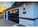 Contemporary garage with black framed windows, stylish exterior lighting, and a sleek, modern design at 1868 E La Donna Dr, Tempe, AZ 85283