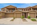 Exterior townhome facade featuring private balcony, stone accents, and spacious two-car garages at 1945 W Desert Vista Trl # 77, Phoenix, AZ 85085