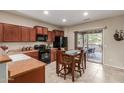 Eat-in kitchen featuring wood cabinets, black appliances, and an inviting patio view through sliding glass doors at 20555 N 261St Ave, Buckeye, AZ 85396