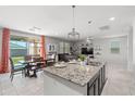 Bright, open-concept space connecting the kitchen island, dining area, and living room, ideal for entertaining at 21407 W Hubbell St, Buckeye, AZ 85396