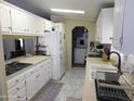 Bright kitchen features white cabinets, updated appliances, and a view of the laundry area at 2400 E Baseline Ave # 153, Apache Junction, AZ 85119