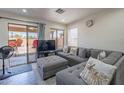 Comfortable living room featuring a plush sectional and sliding glass doors to the backyard at 2714 E Valencia Dr, Phoenix, AZ 85042