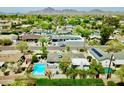 Aerial view of a neighborhood showcasing houses, a street, and a mountain range in the backdrop at 3015 E Sells Dr, Phoenix, AZ 85016