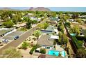Aerial view of a neighborhood featuring houses, green trees, a street, and a mountain in the background at 3015 E Sells Dr, Phoenix, AZ 85016