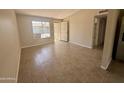Inviting living room featuring neutral walls, tile floors, and a large window for natural light at 3645 N 71St Ave # 28, Phoenix, AZ 85033