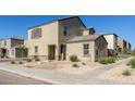 Beige two story home with a brown tiled roof, landscaped front yard, and concrete walkway with front door at 3929 S 79Th Ln, Phoenix, AZ 85043