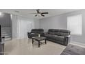 Contemporary living room featuring neutral gray walls, tile flooring, comfortable seating and a ceiling fan at 3929 S 79Th Ln, Phoenix, AZ 85043