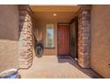 Inviting front entryway with stone pillars, a decorative vase, and a charming wood door at 464 W Bismark St, San Tan Valley, AZ 85143