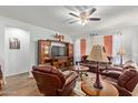 Inviting living room featuring comfortable leather seating, neutral walls, a ceiling fan, and wood-look floors at 5218 W Lydia Ln, Laveen, AZ 85339